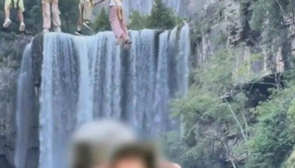 女生瀑布前拍视频,空中突然飘来一排人